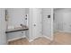 Practical mudroom with a built-in desk area, storage shelves, a white door, and access to a washing machine at 749 Lake Artesia Ln, Fuquay Varina, NC 27526