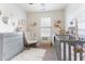 Bright Bedroom featuring a crib, dresser, rocking chair, and soft rug at 8336 Bratt Ave, Wake Forest, NC 27587