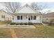 Charming single-story home featuring a cozy front porch with stylish blue shutters, complemented by a well-maintained lawn at 847 Estes St, Durham, NC 27701