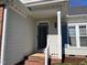 Close-up of a home's entryway, featuring a well-lit porch with brick steps and a storm door at 100 Sandy Hook Way, Cary, NC 27513