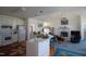 Bright, open-concept kitchen with white cabinets, a breakfast bar, and a view into a spacious living room at 100 Sandy Hook Way, Cary, NC 27513