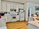 Functional kitchen with white appliances, cabinets, and ample counter space, featuring hardwood floors at 100 Sandy Hook Way, Cary, NC 27513