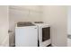 This laundry room features a white washer and dryer along with a wire shelf for storage at 1008 Scotch Pine Way, Mebane, NC 27302