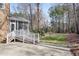 Covered porch and a spacious backyard with green lawn, bordered by mature trees creating a private oasis at 102 Shepton Dr, Cary, NC 27519