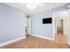 Bright bedroom featuring hardwood floors, light blue walls, and a modern ceiling fan at 102 Shepton Dr, Cary, NC 27519