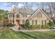 Elegant brick home with a manicured front lawn and mature landscaping, showcasing its classic design at 102 Shepton Dr, Cary, NC 27519