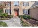 Inviting brick home featuring a red front door, black shutters, and manicured landscaping at 102 Shepton Dr, Cary, NC 27519