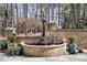 Brick water feature with surrounding landscaping, creating a serene and decorative backyard element at 102 Shepton Dr, Cary, NC 27519