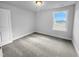 A well lit bedroom featuring neutral carpet, white trim, and a bright window at 104 Whistling Way # Brunswick English Country, Lillington, NC 27546