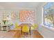 Sunlit dining area with hardwood floors, neutral walls, a large picture window, and eye-catching modern artwork at 105 Fidelity St # B24, Carrboro, NC 27510