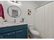 Stylish bathroom with blue vanity, round mirror, quartz countertop, and shower with curtain at 1109 Sorcerer Ct Ct, Knightdale, NC 27545