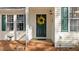Close up view of the front door, showing the yellow wreath, green door and brick steps at 1109 Sorcerer Ct Ct, Knightdale, NC 27545