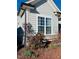 Close-up of home's exterior with stone accents and flowerbed; a window lets in natural light at 111 Kalmia Dr, Durham, NC 27703