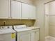 Convenient laundry room with a washer, dryer, wash basin and ample cabinet space at 111 Kalmia Dr, Durham, NC 27703