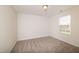 A simple bedroom with neutral carpet, and a large window allowing natural light at 114 Johnson Ridge Way, Four Oaks, NC 27524
