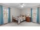 Cozy bedroom with natural light, a ceiling fan, neutral-toned walls, and blue curtains at 115 Perth Pl, Durham, NC 27712