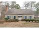 Charming single-story home with a brick chimney and landscaped front yard with inviting blue shutters at 115 Perth Pl, Durham, NC 27712