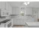 Clean white kitchen with modern appliances, tiled floors, and plenty of cabinet storage space at 115 Perth Pl, Durham, NC 27712