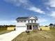 New two-story home featuring a white siding, black shutters, a front-entry two-car garage, and a well-manicured lawn at 120 Whistling Way # Cary Traditiol, Lillington, NC 27546