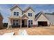 New two-story home with a two-car garage, covered front porch, and stone accents, situated on a lot under construction at 1204 Opal Ln # 93, Durham, NC 27705