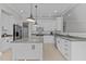 Well-lit kitchen featuring white cabinets, stainless steel appliances, and a granite countertop island at 1208 Anora Dr, Apex, NC 27502