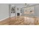 Bright living room with hardwood flooring, a fireplace, custom built-ins, and a large window at 1208 Anora Dr, Apex, NC 27502