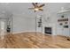 Spacious living room with hardwood floors, a fireplace, built-in shelving, and a ceiling fan at 1208 Anora Dr, Apex, NC 27502