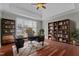 Bright home office with built-in bookshelves, hardwood floors, and a large window offering ample natural light at 1208 Anora Dr, Apex, NC 27502