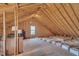 Unfinished attic space with exposed beams, a window, and potential for customization at 149 Winterberry St, Clayton, NC 27527