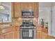 A kitchen with stainless steel appliances, wooden cabinets, and an opening to another room at 149 Winterberry St, Clayton, NC 27527