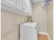 A laundry room with upper white cabinets and a modern washer and dryer at 149 Winterberry St, Clayton, NC 27527