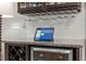 Close-up of a bar area featuring a wine refrigerator, wine rack, glassware storage, and a tablet at 1608 Doubles Ct, Raleigh, NC 27609