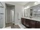 Bathroom featuring a double sink vanity with a tiled shower with glass doors at 1608 Doubles Ct, Raleigh, NC 27609