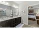 Bathroom showcasing a vanity with a double sink and an open doorway into the bedroom at 1608 Doubles Ct, Raleigh, NC 27609