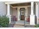 Inviting front porch with classic columns, rocking chairs, and a stylish front door at 1608 Doubles Ct, Raleigh, NC 27609