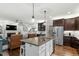Open concept kitchen featuring a large center island, stainless appliances, and views into the living area at 1608 Doubles Ct, Raleigh, NC 27609