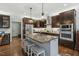 Modern kitchen with stainless appliances, dark wood cabinets, granite countertops, and a large island with seating at 1608 Doubles Ct, Raleigh, NC 27609