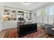 Well-lit home office with built-in shelves, large desk, and comfortable armchair at 1608 Doubles Ct, Raleigh, NC 27609