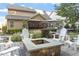 Beautiful backyard area featuring a stone fire pit, comfortable Adirondack chairs, and mature landscaping at 1608 Doubles Ct, Raleigh, NC 27609