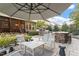 Relaxing outdoor space featuring an umbrella-covered patio, outdoor kitchen, and bar-style seating at 1608 Doubles Ct, Raleigh, NC 27609