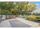 Inviting outdoor patio featuring a stone kitchen, comfortable seating, lush landscaping, and stone pavers at 1608 Doubles Ct, Raleigh, NC 27609