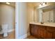 Neutral bathroom boasting wood cabinets, double sinks, and a toilet in an adjacent room at 17 Beckwith Ave, Clayton, NC 27527