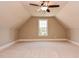 Large bonus room with carpet and natural light from the window, enhanced by a ceiling fan at 17 Beckwith Ave, Clayton, NC 27527