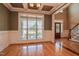 Formal dining room with hardwood floors, wainscoting, coffered ceiling, and large window at 17 Beckwith Ave, Clayton, NC 27527