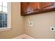 This laundry room provides essential utility, abundant storage in brown cabinets, and a window for natural light at 17 Beckwith Ave, Clayton, NC 27527