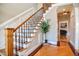 Elegant staircase with hardwood steps, iron balusters, and view into living room at 17 Beckwith Ave, Clayton, NC 27527