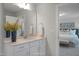 Modern bathroom vanity with a large mirror, decorative vase, and access to the main bedroom at 1783 Ballard Rd # Apex Georgian, Fuquay Varina, NC 27526