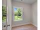 Bright, minimalist bedroom with hardwood floors and a large window offering a serene outdoor view at 1783 Ballard Rd # Apex Georgian, Fuquay Varina, NC 27526