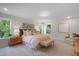Spacious main bedroom featuring two large windows, an upholstered bed, bench, and neutral decor at 1783 Ballard Rd # Apex Georgian, Fuquay Varina, NC 27526