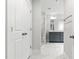 Hallway view of bathroom, showcasing gray double vanity, marble flooring, and glass enclosed shower at 1803 Ballard Rd # Holly Craftsman, Fuquay Varina, NC 27526
